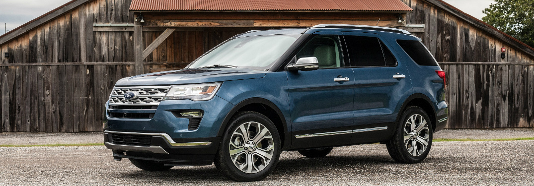 Image of a blue 2019 Ford Explorer parked in front of a barn.