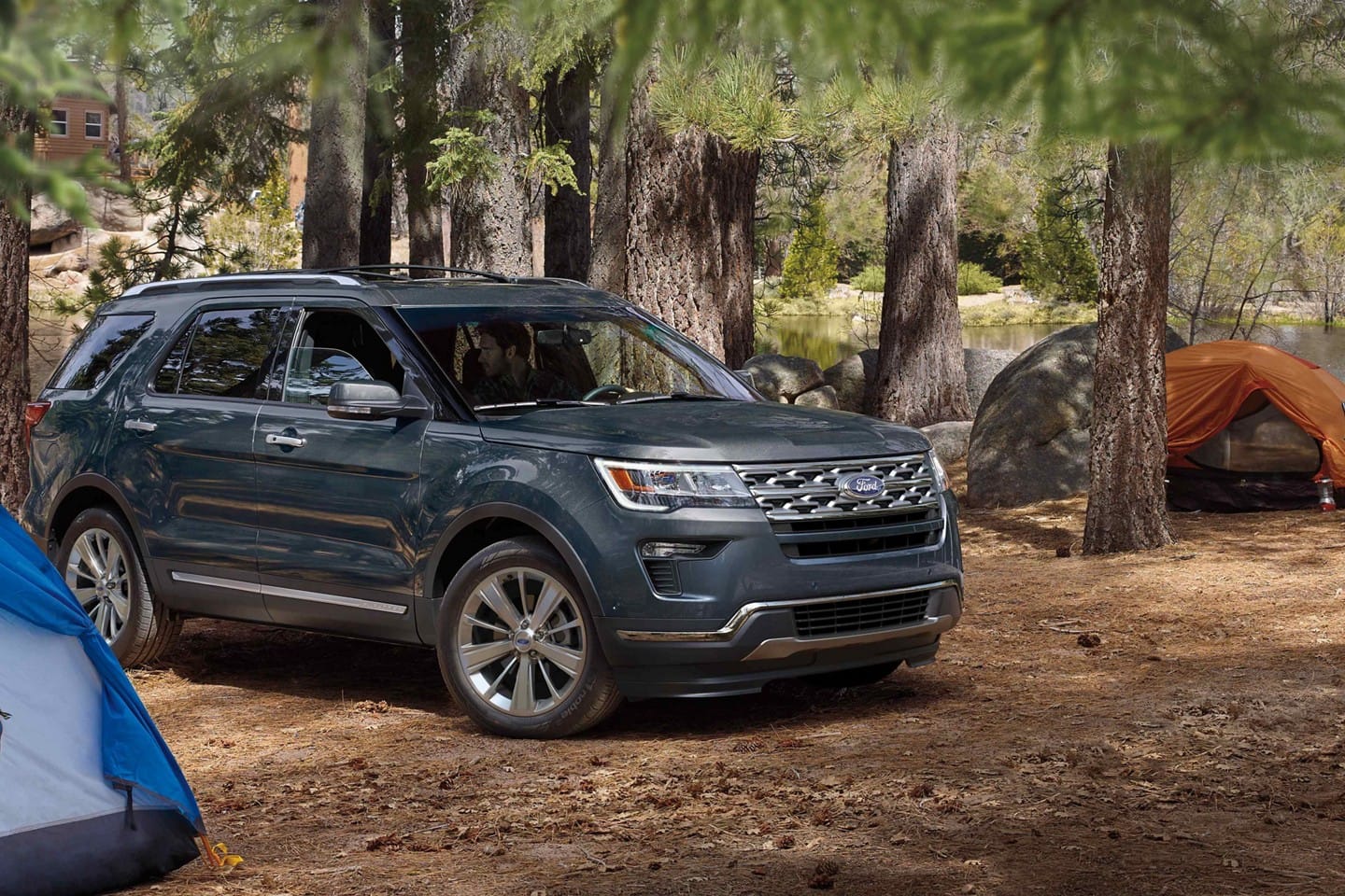 Image of a dark blue 2019 Ford Explorer parked at a campsite.